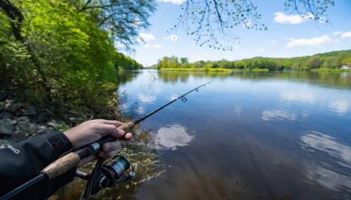 Person off camera bass fishing on edge of a Texas river