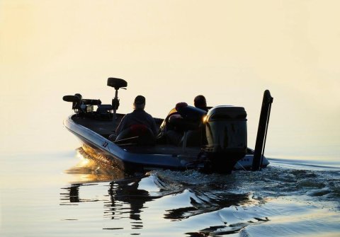 Two men in a bass fishing boat on a river.